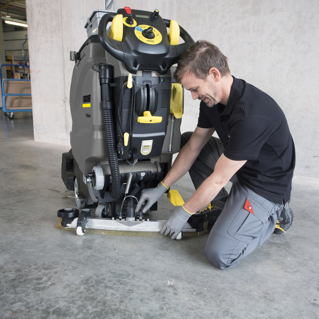 Option Verbrauchsmaterial und Batterie ist Teil der Kärcher Servicepakete Ein Mitarbeiter repariert eine Kärcher Maschine
