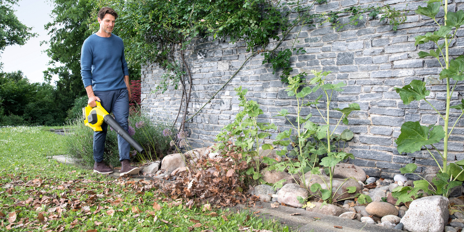 Remove leaves in the garden A man removes leaves in the garden with a Kärcher leaf blower